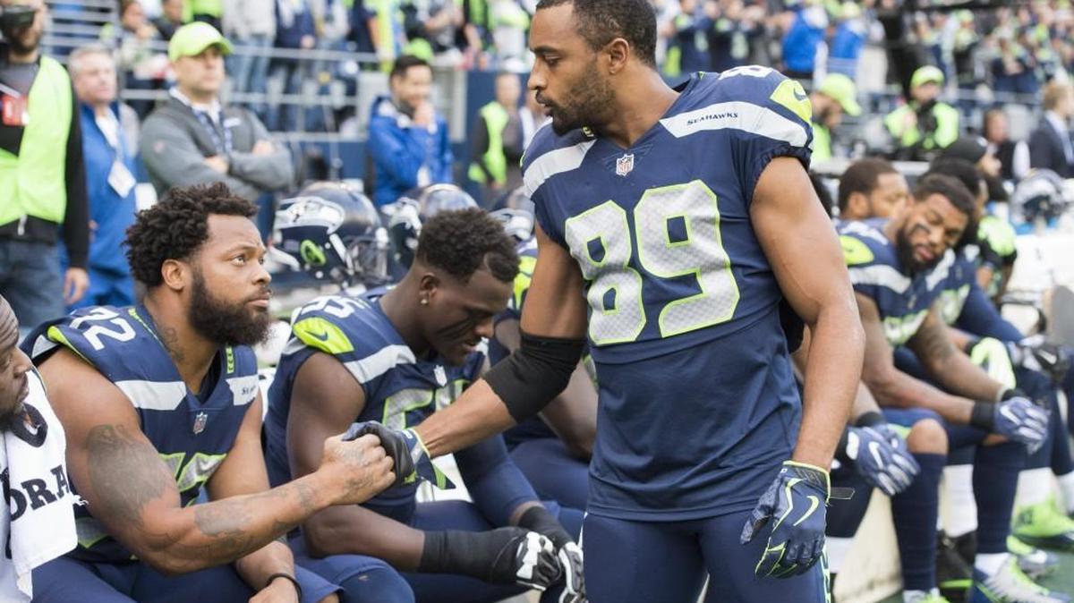 Seahawks wide receiver Doug Baldwin greets teammate Michael Bennett before Bennett sat during the national anthem at the home game Oct. 1 against Indianapolis. Baldwin said Tuesday "I'm not surprised, I'm disappointed" with the NFL's new policy on national-anthem protesting that owners approved earlier in the day.