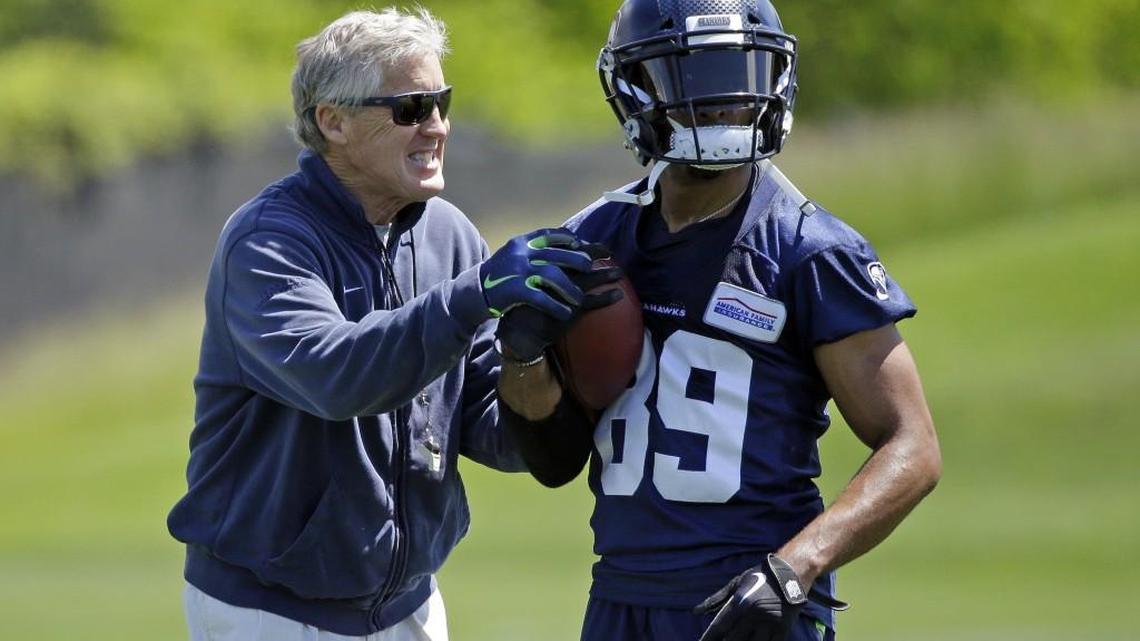 Seahawks wide receiver Doug Baldwin jokes with coach Pete Carroll, left, during an organized team activity during last offseason. The NFL has set the dates for Seattle's 2018 OTAs and one, mandatory minicamp of this offseason.