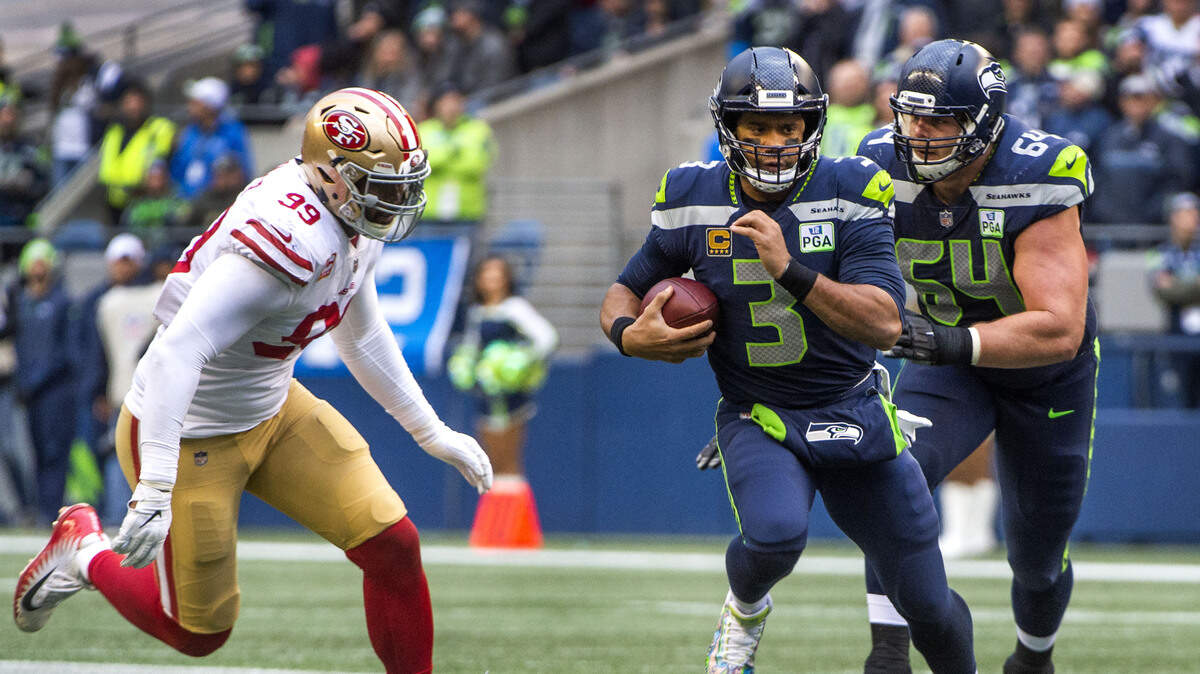 Russell Wilson scrambles for a gain as 49ers defensive lineman DeForest Buckner closes in during the Seahawks’ home win last weekend at CenturyLink Field. This wasn’t the play about which San Francisco complained that Wilson threw a shoe of a 49ers players up the field to gain an advantage for Seattle’s offense.