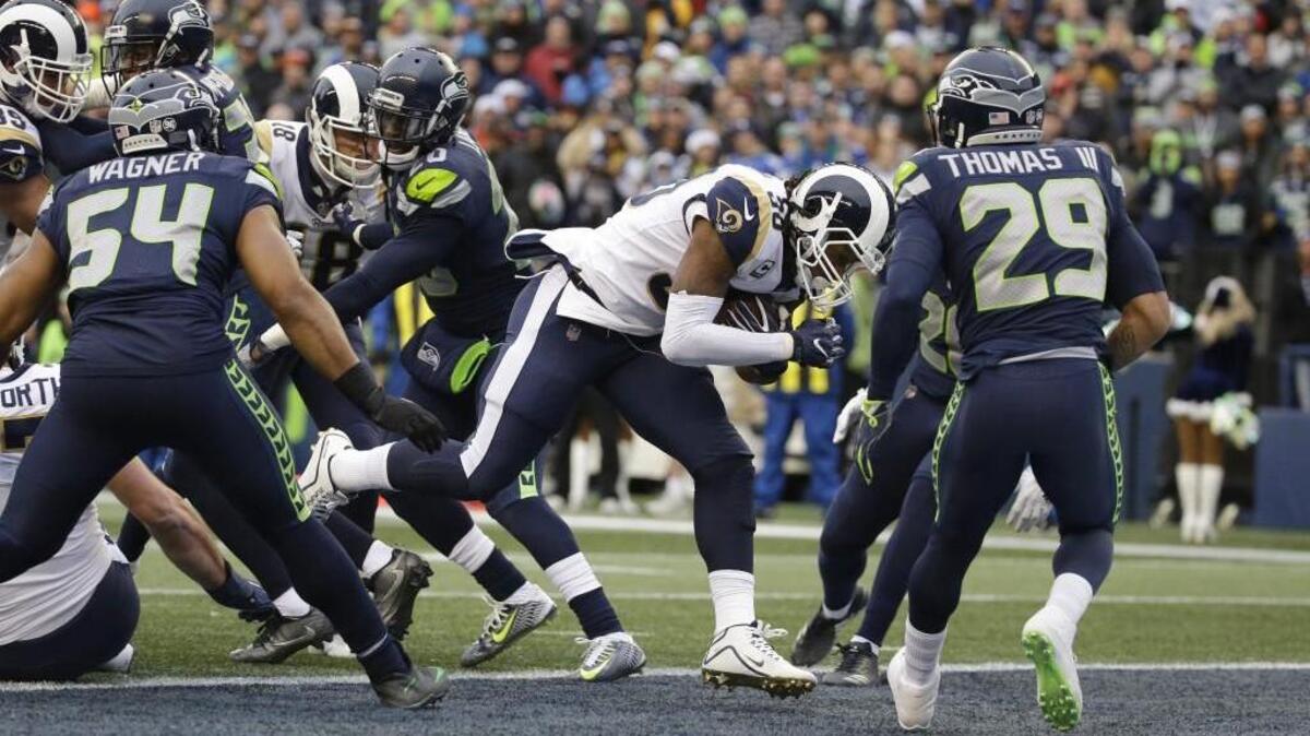 Los Angeles Rams running back Todd Gurley, second from right, rushes for a touchdown as Seattle Seahawks' Bobby Wagner (54) and Earl Thomas (29) look on in the first half.