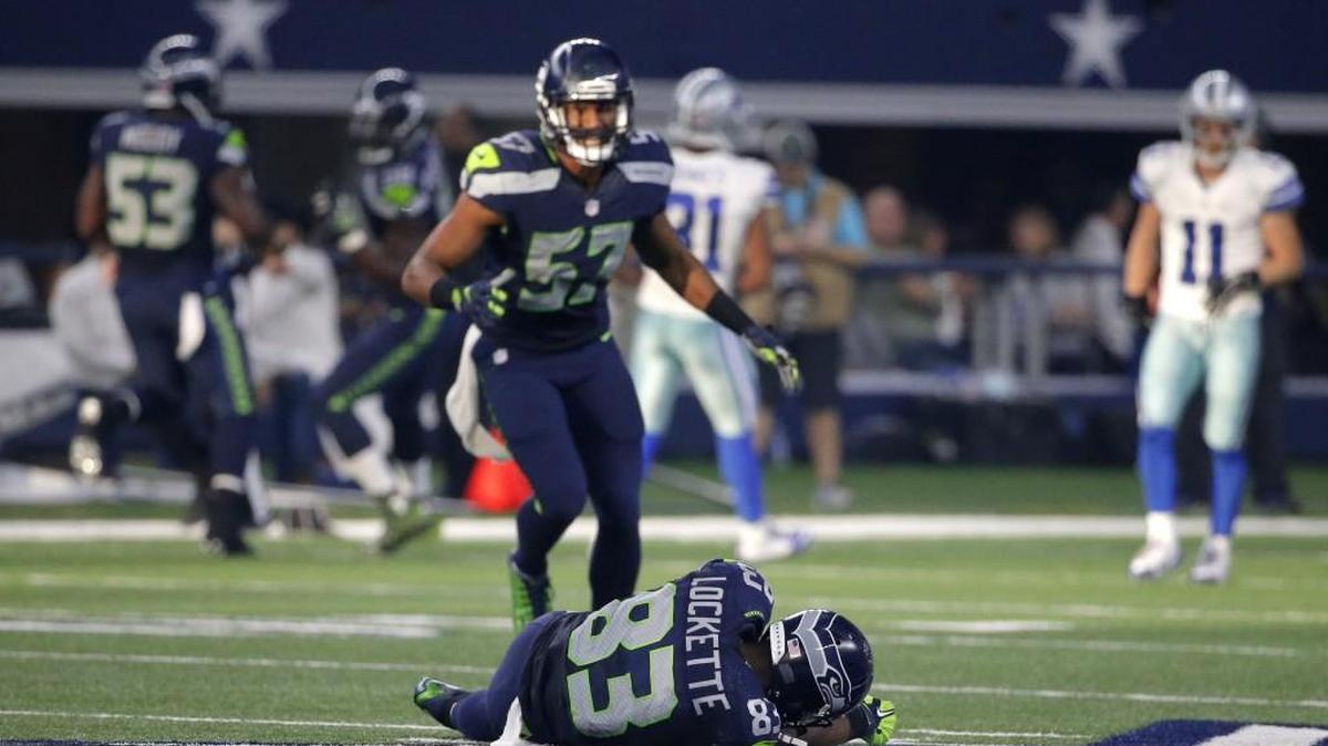 Seattle Seahawks' Mike Morgan (57) looks down at wide receiver Ricardo Lockette (83) who lays on the ground after suffering an injury in the first half of an NFL football game against the Dallas Cowboys Sunday, Nov. 1, 2015, in Arlington, Texas.