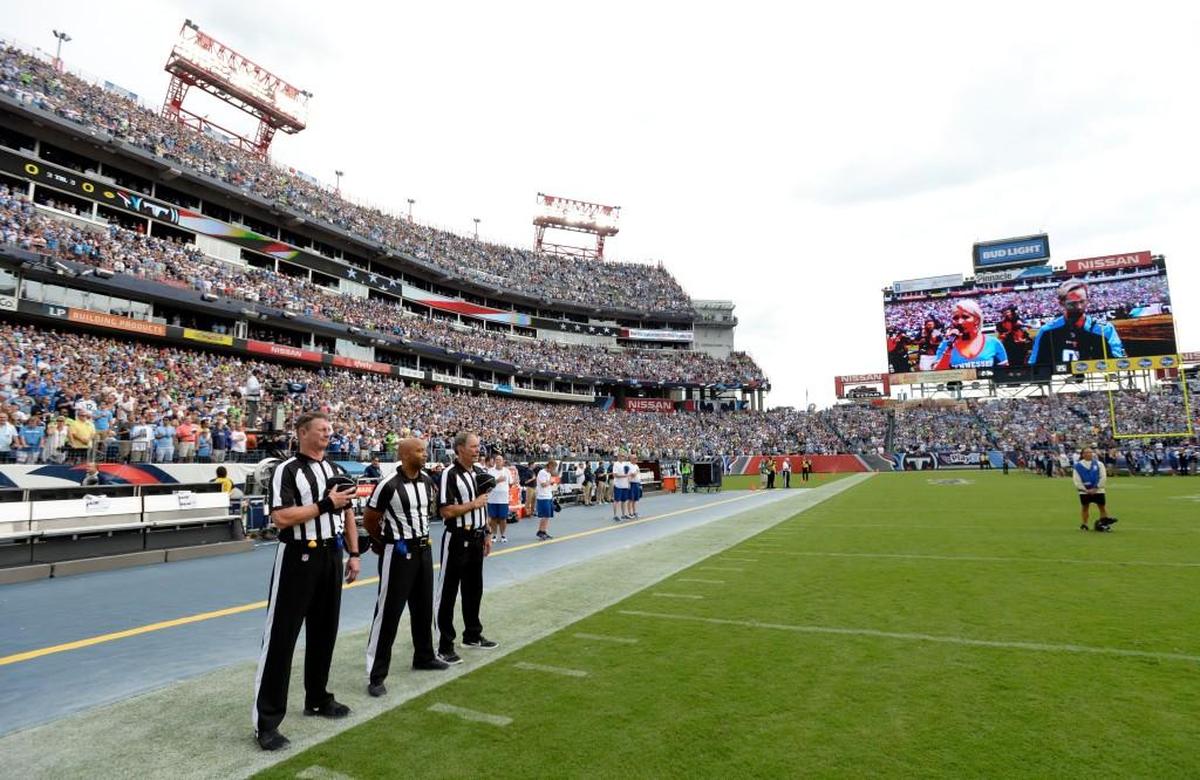 Officials stand on the sideline of the Seattle Seahawks during the playing of the national anthem before an NFL football game between the Seahawks and the Tennessee Titans Sunday, Sept. 24, 2017, in Nashville, Tenn. Neither team came out onto the field for the anthem.