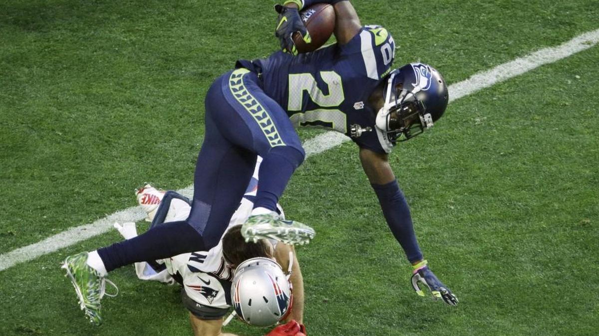 Seattle Seahawks cornerback Jeremy Lane (20) is upended by New England Patriots wide receiver Julian Edelman (11) after an interception during the first half of Super Bowl XLIX on Feb. 1, 2015, in Glendale, Arizona.