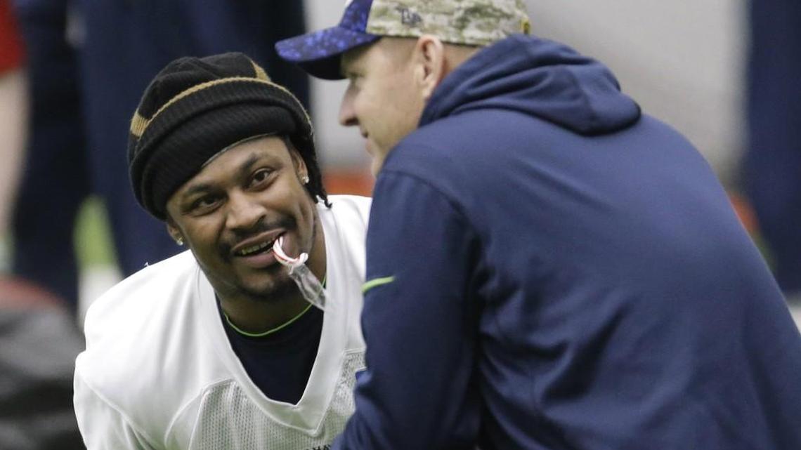 Seattle’s Marshawn Lynch, left, talks with offensive coordinator Darrell Bevell, right, before practice on Jan. 6. Lynch, who did not play in Sunday’s win at Minnesota, participated in practice Wednesday and Bevell said he looked good. The team did not say if he would play against Carolina.