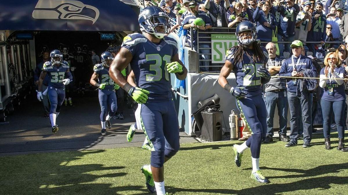 
Fans roar as Seahawks strong safety Kam Chancellor, left, makes his first appearance at CenturyLink Field after ending his long holdout last week. Cornerback Richard Sherman is alongside him.
