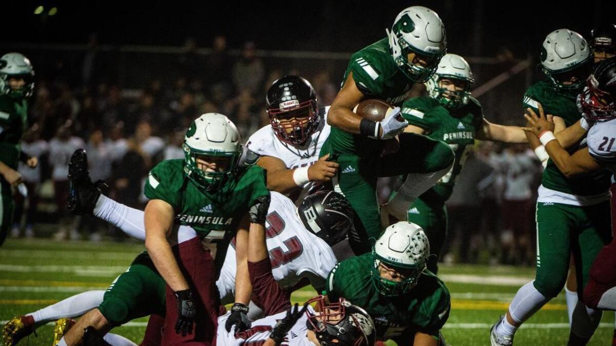 Peninsula’s Braeden Potter (30) leaps over a cluster of players during a run in the first quarter. Peninsula High School payed Bethel in a football game at Roy Anderson Field in Purdy, Wash., on Friday, Nov. 9, 2018.