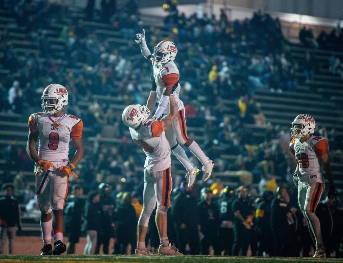 Lakes’ Alan Fischer (58) hoists Daeshawn Wayne (1) into the air after Wayne’s touchdown catch in the fourth quarter. Lincoln high school played Lakes high school in a football game at the Lincoln Bowl in Tacoma, Wash., on Friday, Oct. 19, 2018.