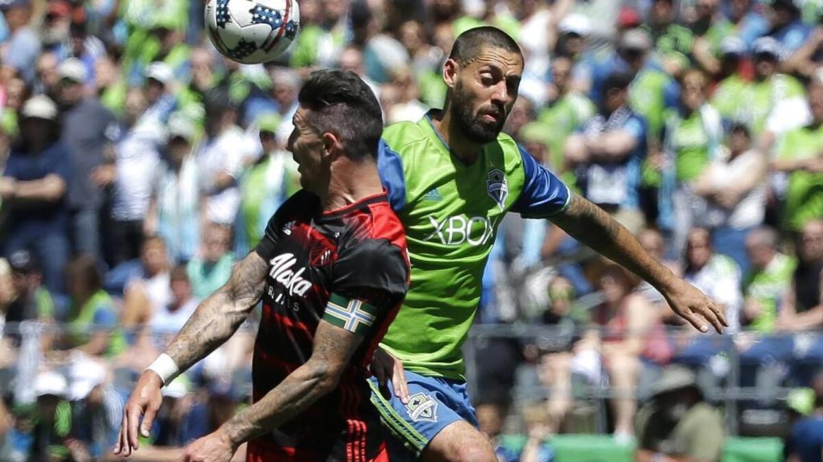 Seattle Sounders' Clint Dempsey, right, and Portland Timbers defender Liam Ridgewell battle for a header in Sounders’ 1-0 win back in May in Seattle.