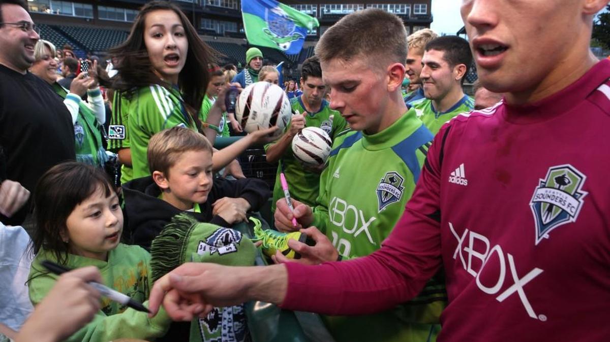 Seattle Sounders U-23 defender Mark Lee (center) and goalkeeper Doug Herrick sign autographs following their soccer match against the Vancouver Whitecaps at Cheney Stadium in Tacoma on Wednesday, May 30, 2012. The teams played to a 3-3 tie.
