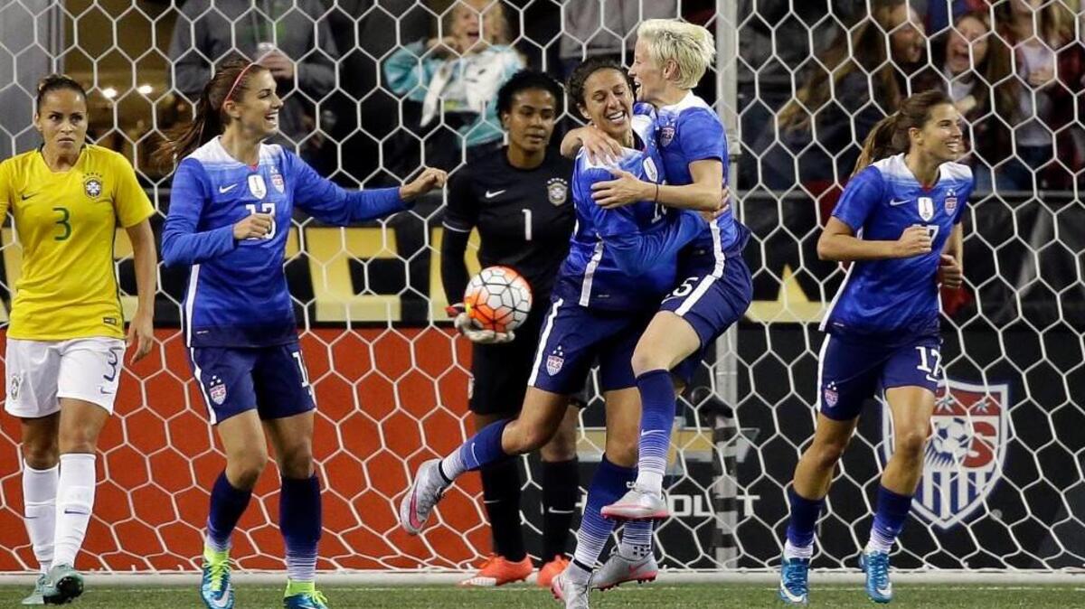 United States’ Carli Lloyd, center right, is embraced by Megan Rapinoe on Wednesday after scoring against Brazil during the second half of an international friendly soccer match in Seattle. The teams played to a 1-1 draw.
