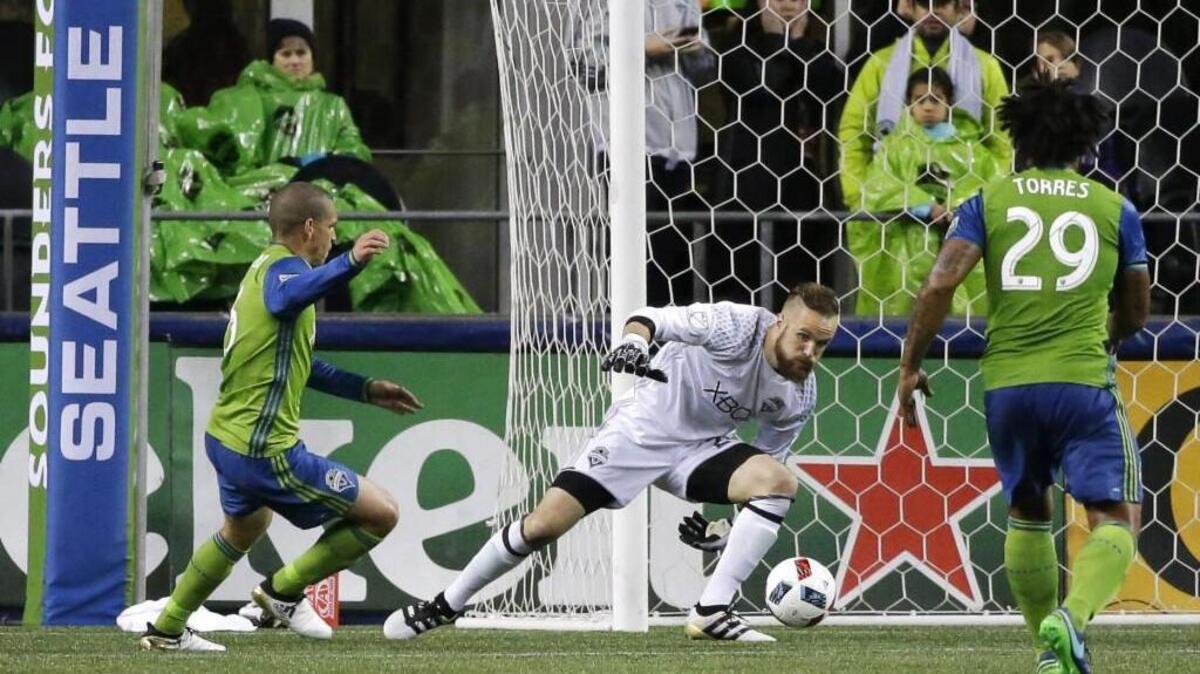 Sounders goalkeeper Stefan Frei, center, makes a save against Sporting Kansas City on Thursday in the second half of an MLS soccer playoff match. The Sounders won 1-0.