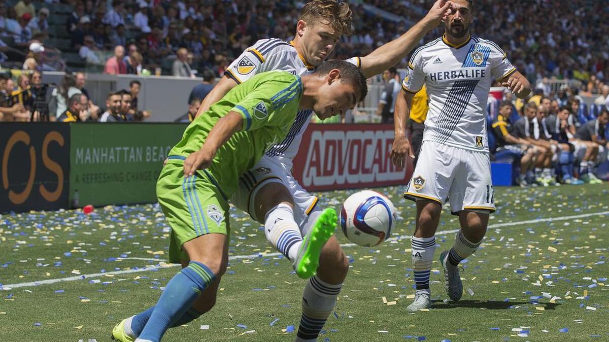 
Los Angeles Galaxy midfielder Robbie Rogers (14) controls the ball against Seattle Sounders FC midfielder Cristian Roldan on Sunday at the StubHub Center in Carson, Calif.
