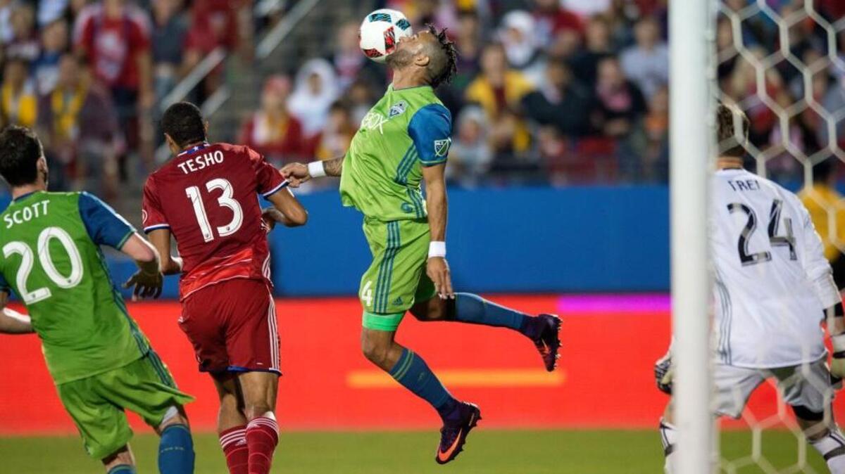 Seattle Sounders defender Tyrone Mears (4) heads the ball away from the goal as Seattle defender Zach Scott (20) and FC Dallas forward Tesho Akindele (13) give chase during the first half of an MLS soccer western conference semifinal playoff match Sunday, Nov. 6, 2016 in Frisco, Texas. Though Dallas won 2-1, Seattle advanced to the western conference championship on aggregate score.