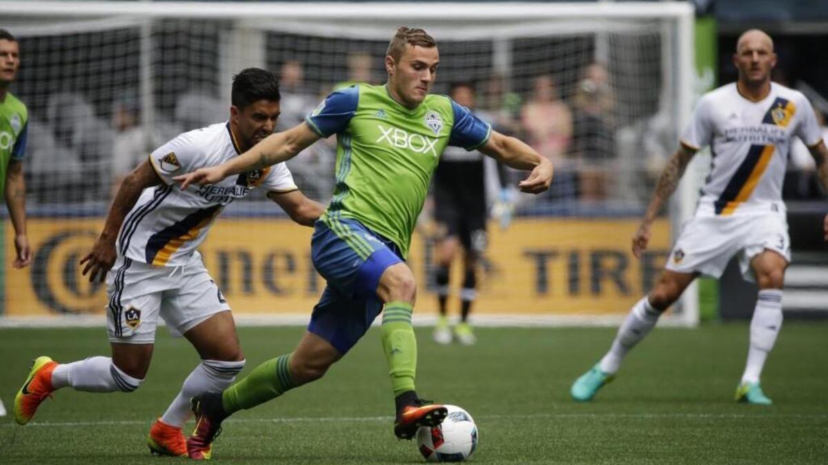 Seattle Sounders forward Jordan Morris drives past the Los Angeles Galaxy’s A. J. DeLaGarza, left, in the first half of an MLS match July 9 in Seattle.