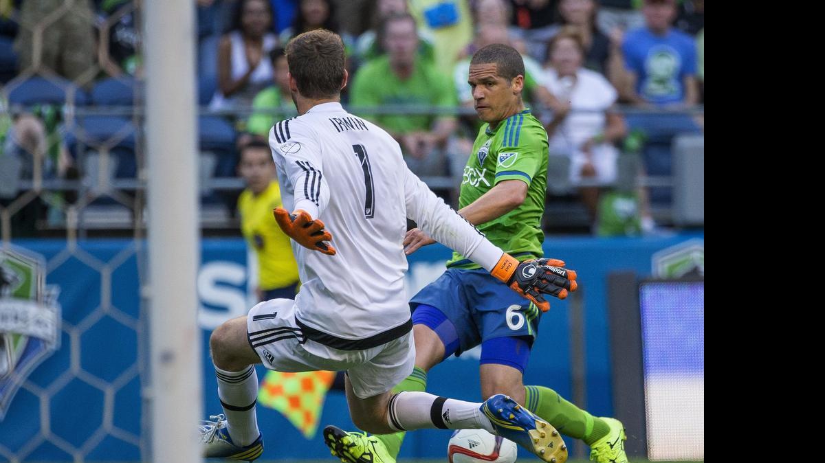 
The Sounders’ Osvaldo Alonso, right, draws Rapids goalkeeper Clint Irwin out of the goal during the first half Saturday night. 
