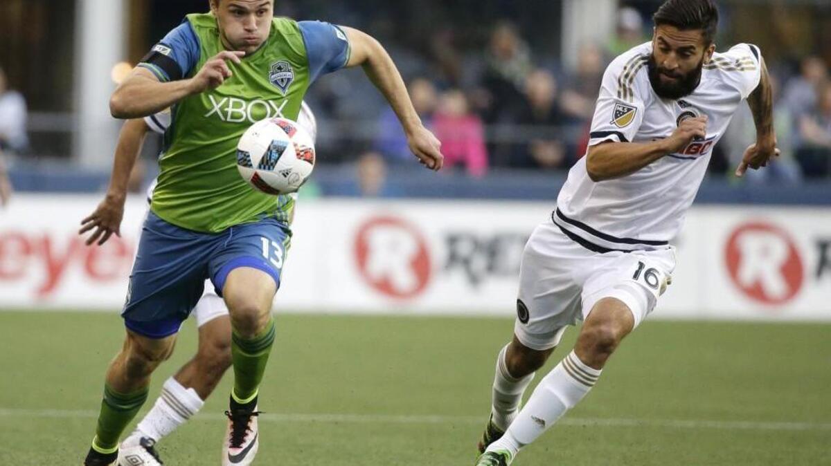 Sounders Jordan Morris, left, drives with the ball as Philadelphia 's Richie Marquez pursues during the first half of an MLS soccer match.