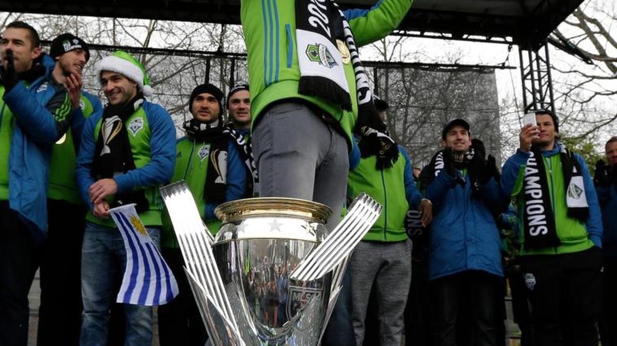 Seattle Sounders goalkeeper Stefan Frei stands next to the MLS Cup trophy during a celebration rally at the Seattle Center, Tuesday, Dec. 13, 2016, in Seattle. The Sounders beat Toronto FC on Dec. 10, 2016 to win the MLS soccer championship. (AP Photo/Ted S. Warren)