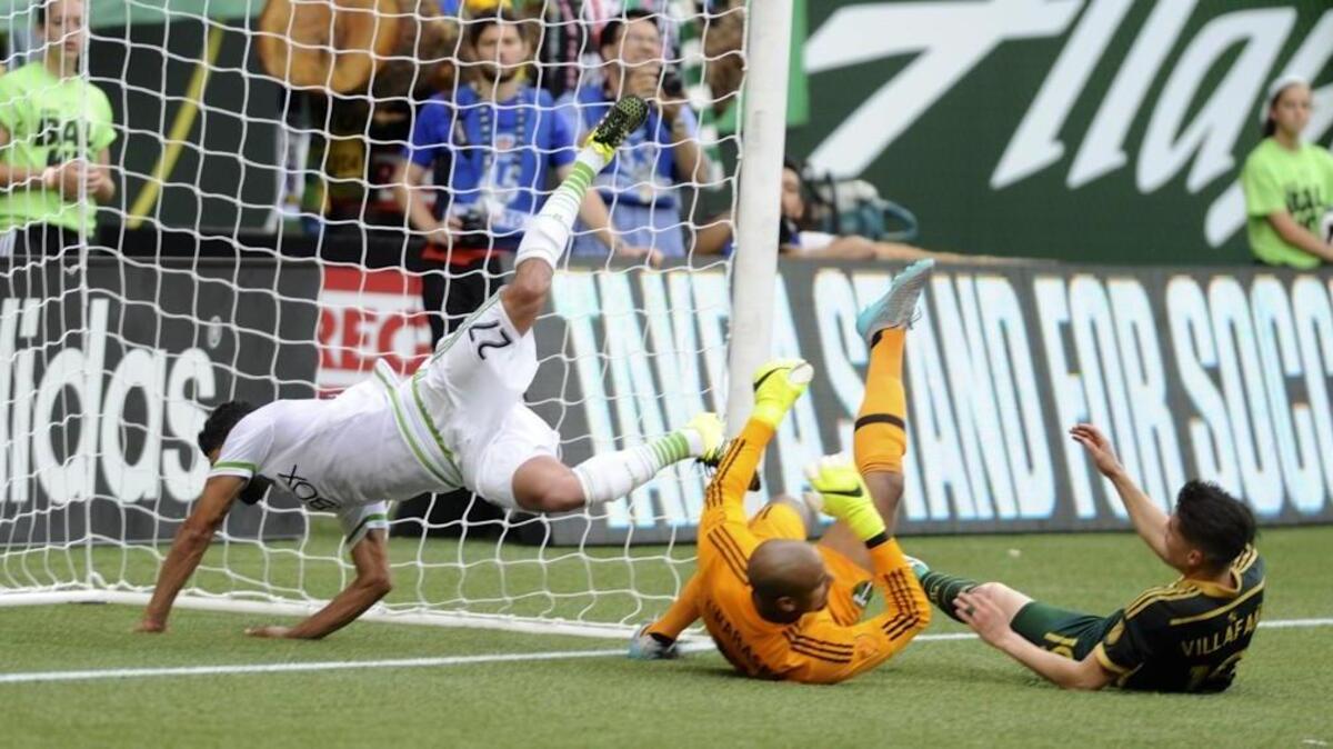 
Seattle’s Lamar Neagle (27) scores against Portland goalie Adam Kwarasey, center, during the first half of the Sounders’ 4-1 loss to Timbers on June 28. Coach Sigi Schmid says the Sounders’ rivalry versus the Timbers is one of the best in the MLS.
