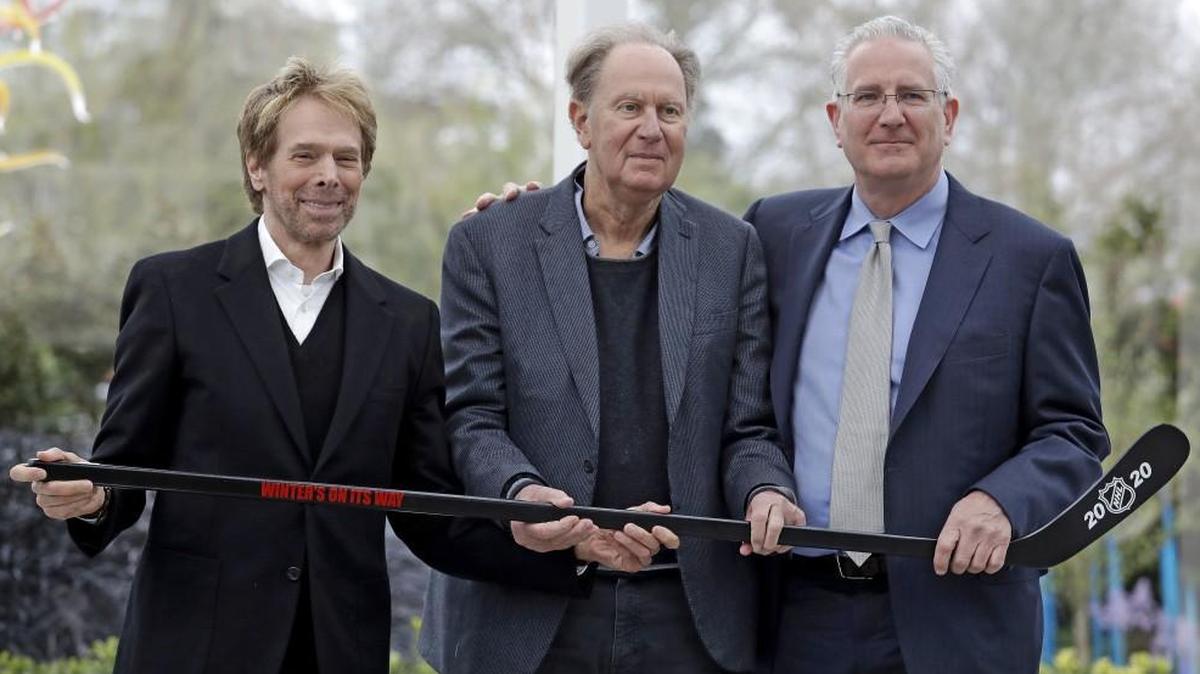 Part owners Jerry Bruckheimer, left, and David Bonderman, center, pose with Tod Leiweke and a hockey stick during a news conference naming Leiweke as the president and CEO for a prospective NHL expansion team, Wednesday in Seattle. Leiweke is the brother of Tim Leiweke, the CEO of the group heading the redevelopment of the arena which would serve as a home for a new hockey team. The group is seeking to have a team awarded in time to begin play in 2020.