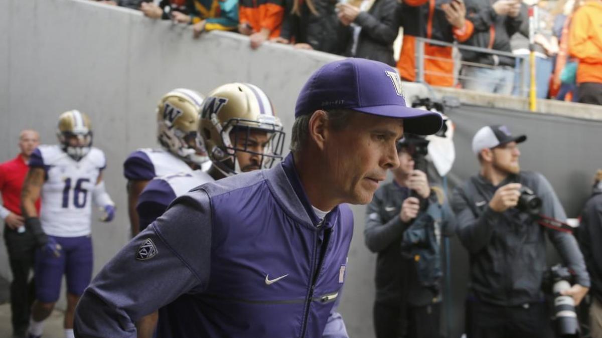 Washington head coach Chris Petersen runs onto the field before game against Oregon State. As annoying as late kickoffs are for fans, TV networks paid handsomely for the right to broadcast those games at night.