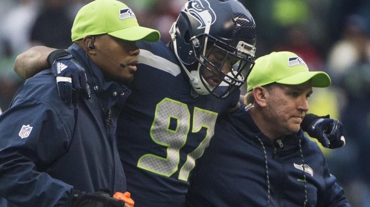 Seahawks defensive lineman Marcus Smith is helped off the field after colliding with Seahawks linebacker K.J. Wright during a play in the third quarter against Washington. With a short week because of a game on Thursday, the Seahawks have less time to heal – both mentally and physically.