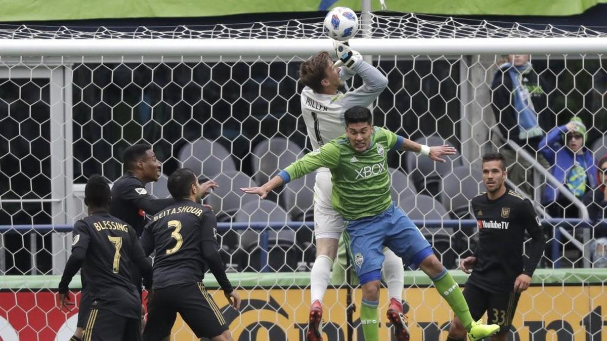 Seattle Sounders defender Tony Alfaro, second from right, collides with Los Angeles goalkeeper Tyler Miller during the first half of an MLS soccer match, Sunday, March 4, 2018, in Seattle.