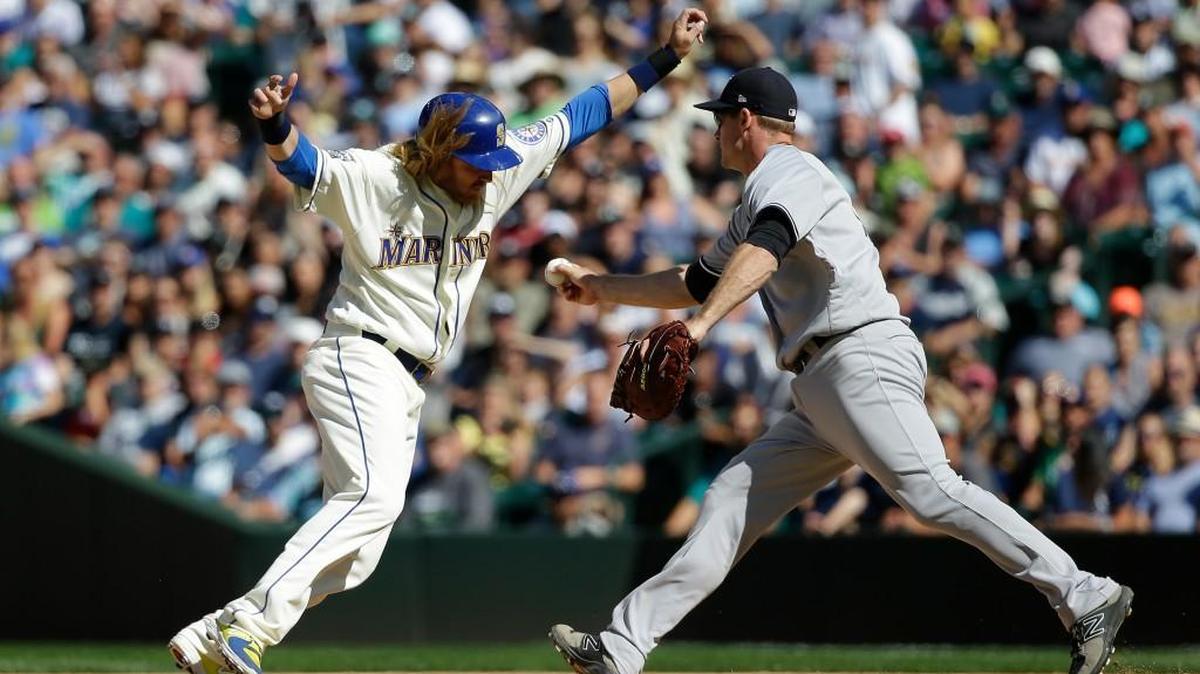 Seattle’s Taylor Motter is tagged out by New York first baseman Chase Headley on Sunday in a pickoff at first base in the ninth inning in Seattle. Motter was pinch-running for Nelson Cruz, who had led off the inning with a single.