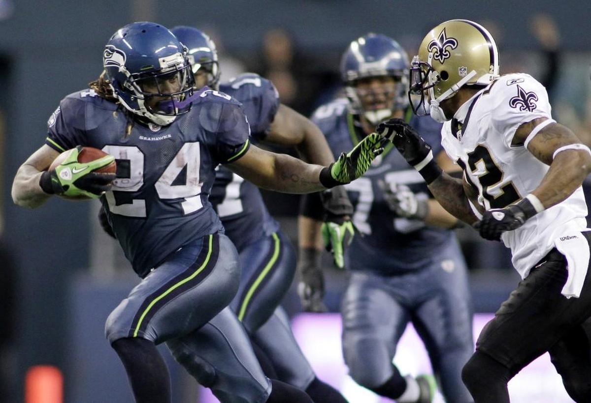 The Seattle Seahawks’ Marshawn Lynch (24) breaks away from the tackle of the New Orleans Saints’ Tracy Porter to score a 67-yard touchdown during the second half of wild card game Jan. 8, 2011, in Seattle. The Seahawks won, 41-36.