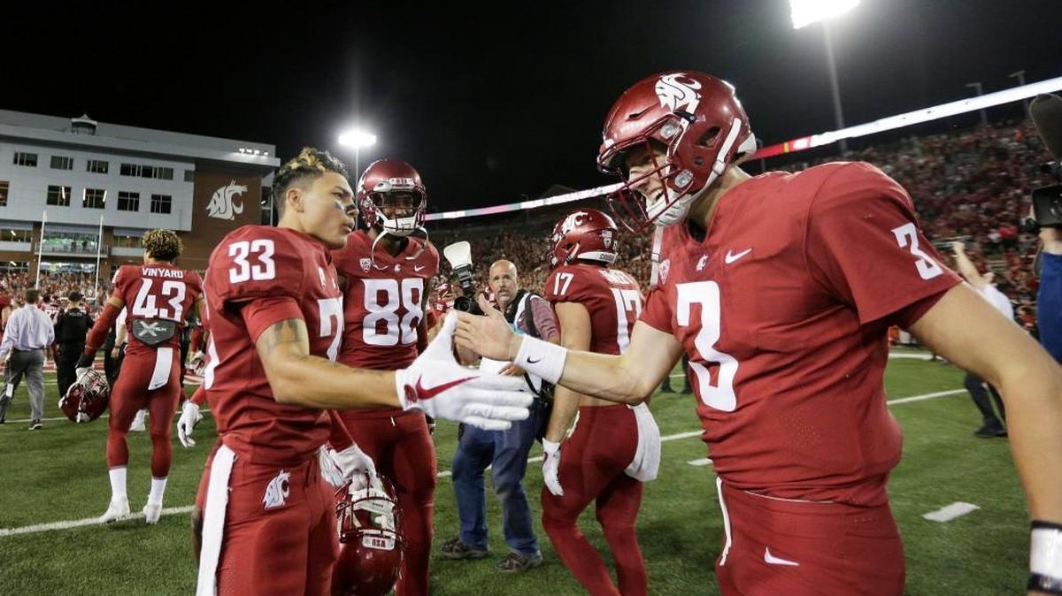 Washington State wide receiver Kainoa Wilson, left, congratulates Tyler Hilinski after the quarterback engineered a 47-44 triple overtime, comeback victory over Boise State in September. Hilinski was found dead Tuesday night.