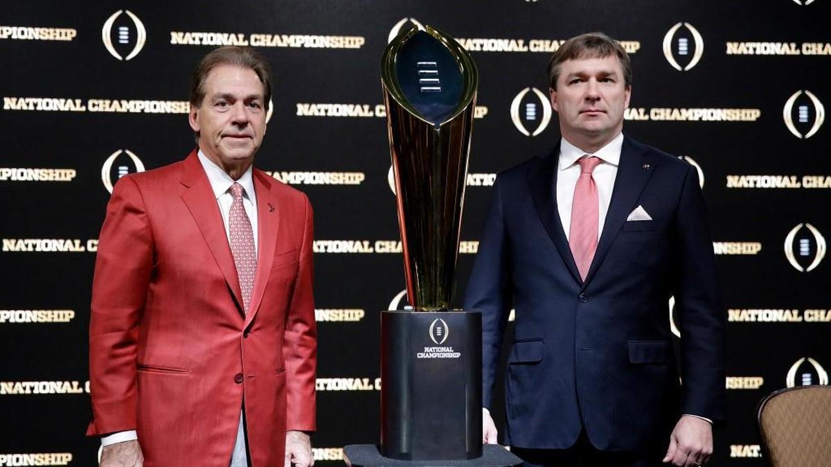 Alabama head coach Nick Saban, left, and Georgia head coach Kirby Smart pose with the NCAA college football championship trophy at a press conference in Atlanta, Sunday. Georgia and Alabama will be playing for the championship on Monday.