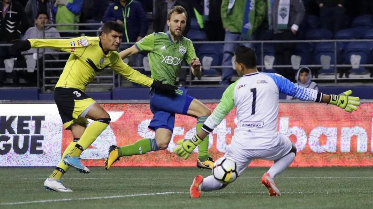 Seattle Sounders midfielder Magnus Wolff Eikrem, center, shoots past Santa Tecla goalkeeper Joel Almeida (1) to score a goal as Santa Tecla defender Roberto Dominguez, left, watches during the second half of a CONCACAF Champions League soccer match Thursday, March 1, 2018, in Seattle. The Sounders won 4-0.