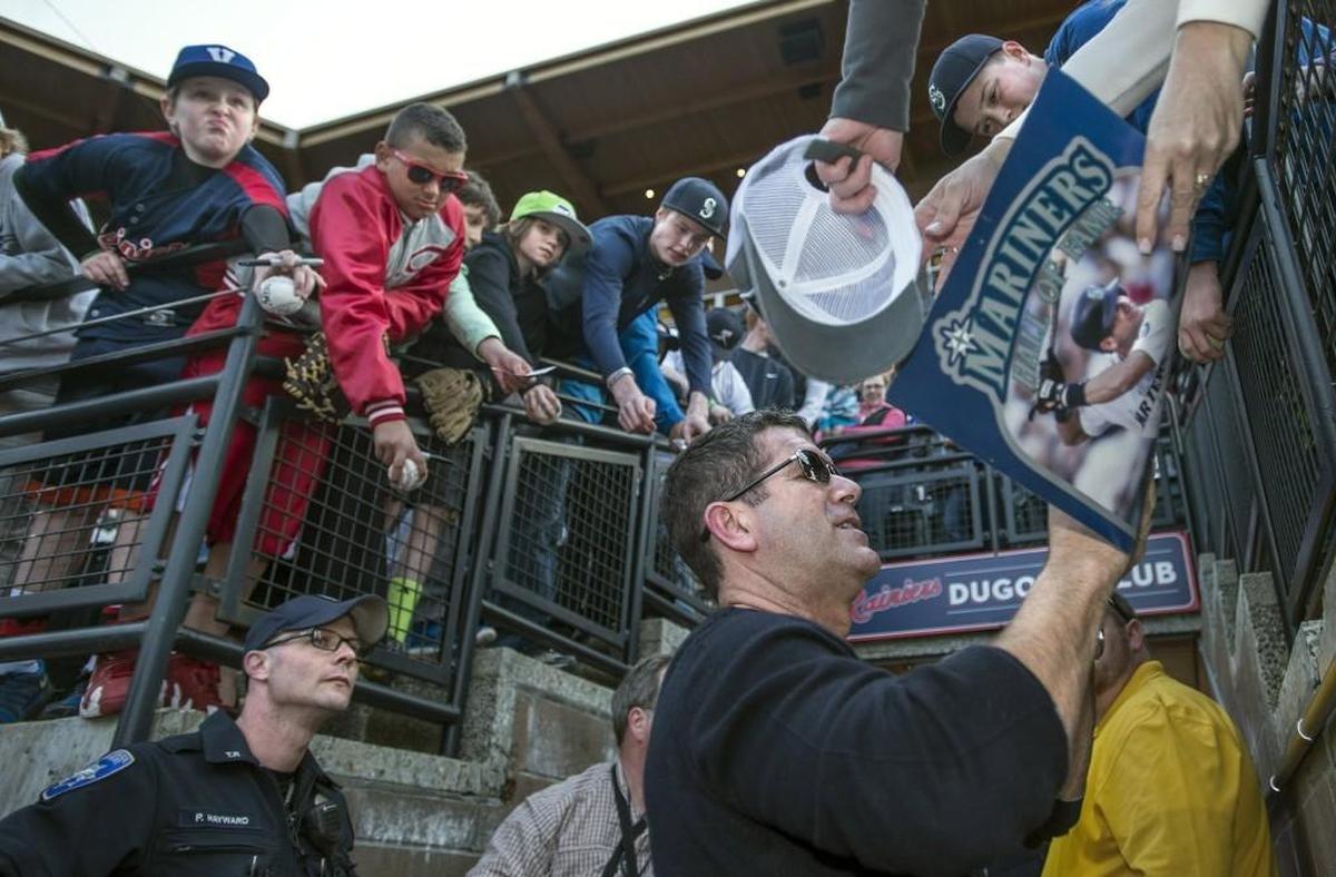 After landing in a helicopter in center field and throwing out the first pitch, Mariners’ great Edgar Martinez signs autographs before the start of the Tacoma Rainiers’ home opener April 16, 2015, at Cheney Stadium against the El Paso Chihuahuas.