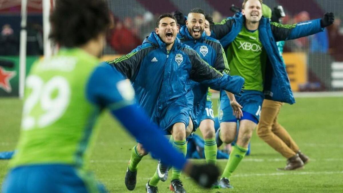 Seattle midfielder Cristian Roldan, second left, along with teammates chase down Sounders defender Roman Torres (29) after he scored the game-winning shootout goal Saturday to defeat Toronto FC in an MLS Cup final soccer game in Toronto.