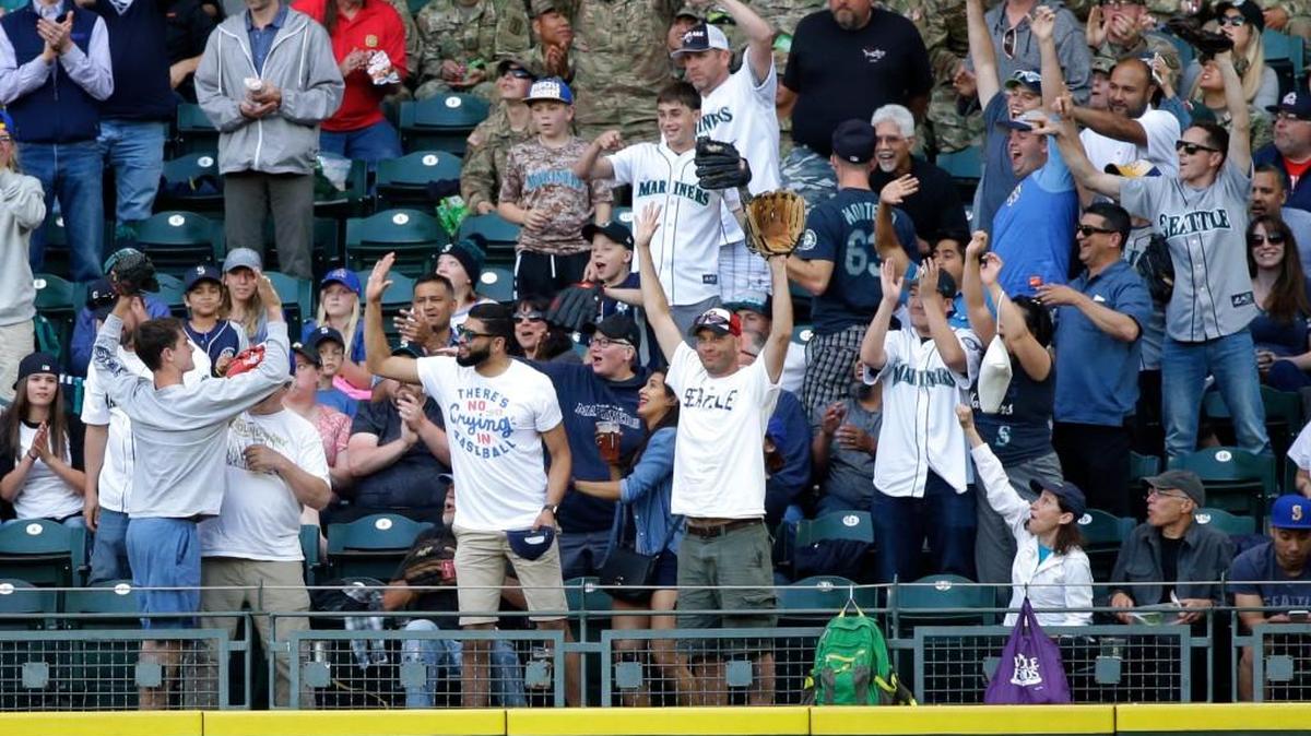 Fans cheer after the fan at lower left caught a two-run home run by Seattle Mariners' Jean Segura against the Philadelphia Phillies in June at Safeco Field. Despite an ever-changing rotation, a series of injuries and a brutal road trip in August, the Mariners are still in postseason contention.