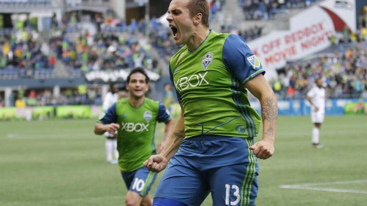 Seattle Sounders forward Jordan Morris, right, celebrates after scoring a goal in the 81st minute against the Vancouver Whitecaps with assists from Nicolas Lodeiro, left, and Erik Friberg, not shown, in the second half of an MLS soccer match, Saturday, Sept. 17, 2016, in Seattle. The Sounders beat the Whitecaps 1-0. (AP Photo/Ted S. Warren)