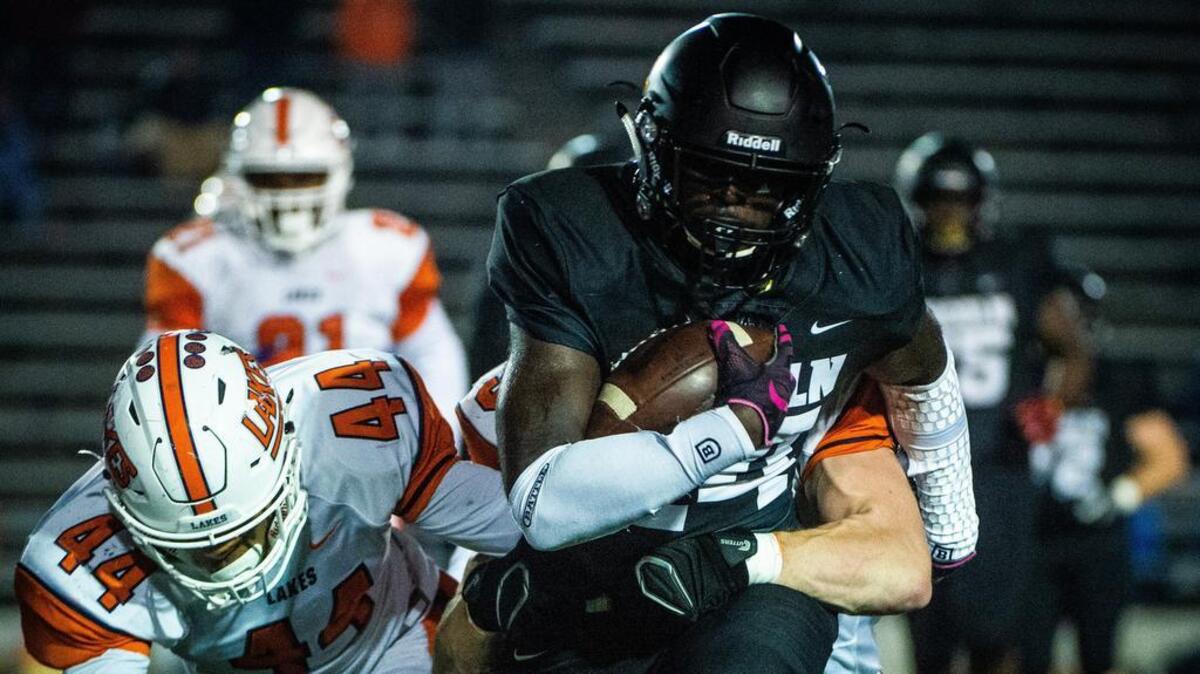 Lakes players tackle Lincoln’s Julien Simon (24) in the first quarter. Lincoln high school played Lakes high school in a football game at the Lincoln Bowl in Tacoma, Wash., on Friday, Oct. 19, 2018.