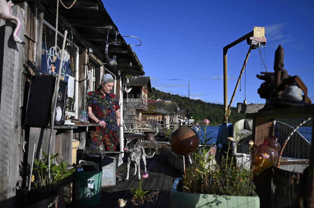 Neon artist Galen Turner and his dog Coupon at their home in the secluded Salmon Beach neighborhood, on Wednesday, June 3, 2026, in Tacoma.