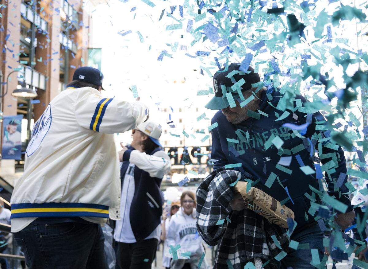A fan gets blasted with confetti as the home-plate gates open two hours before first pitch of the opening day Major League Baseball game between the Mariners and the Cleveland Guardians at T-Mobile Park, on Thursday, March 26, 2026, in Seattle.