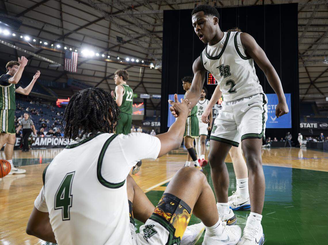Emerald Ridge guard Darius Alexander (2) helps up teammate Jordan Bennett (4) after getting fouled by Redmond during the first round of the 4A State Tournament at the Tacoma Dome, on Wednesday, March 4, 2026, in Tacoma, Wash.