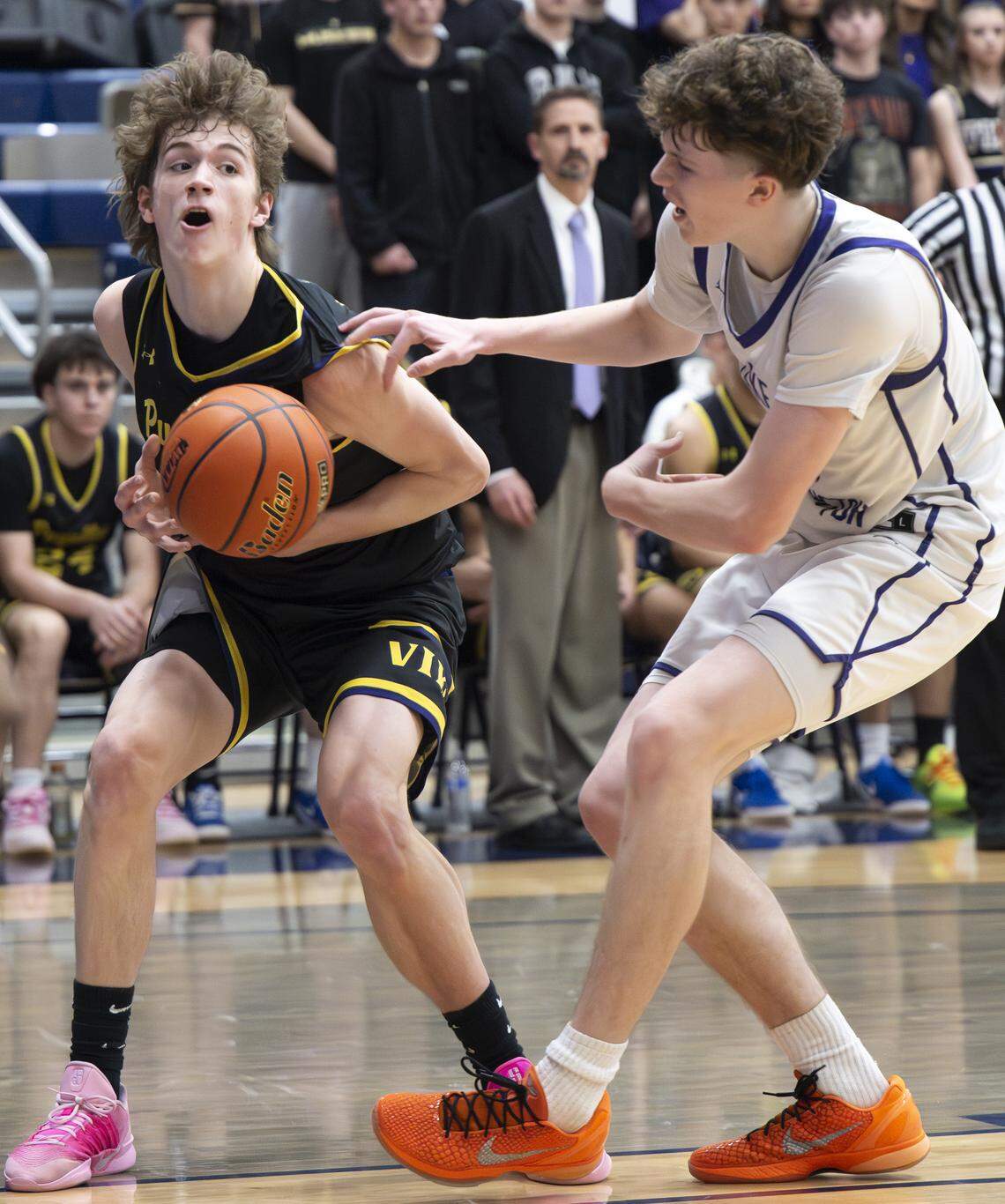 Puyallup post Will Nasinec (25) fouls Lake Washington forward Mateo Cummings (11) during the regional round of the 4A state basketball tournament at Bellevue College, on Saturday, Feb. 28, 2026, in Bellevue.