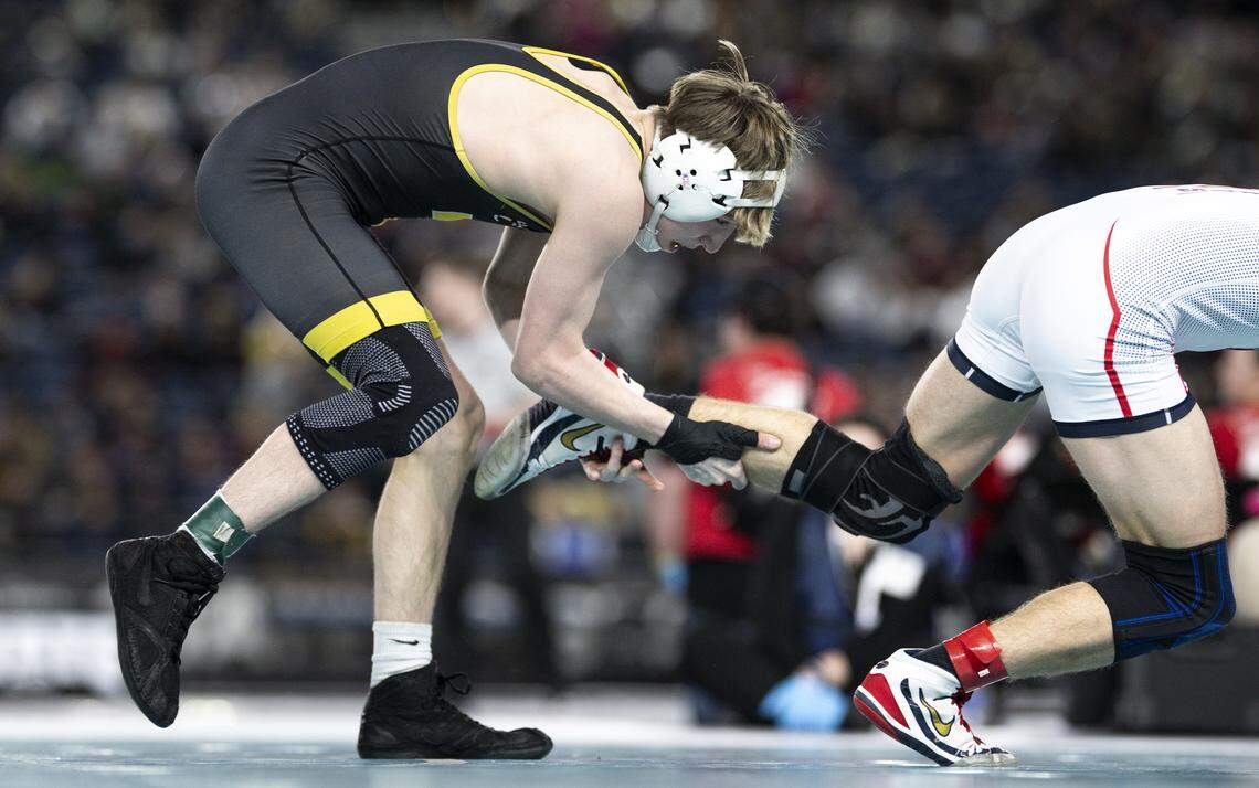 Tahoma’s Owen Marshall picks the ankle of Eisenhower’s Jarek Dobbie in the Boys 4A 132-pound Championship match during the Mat Classic XXXVII at the Tacoma Dome, on Friday, Feb. 20, 2026, in Tacoma, Wash.