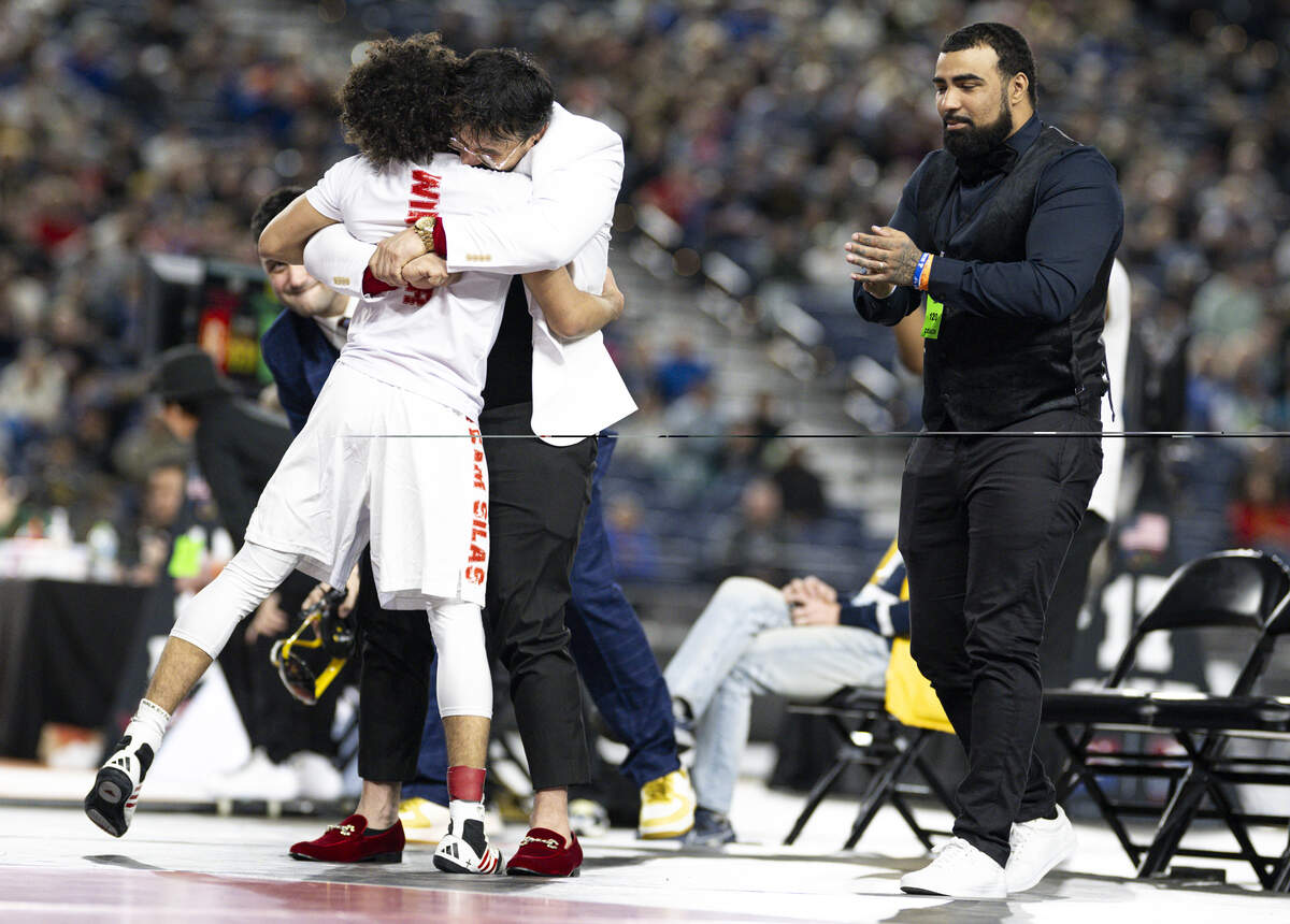 Silas’s Adrian Windsor hugs his coaches after beating Todd Beamer’s Caleb Clemans in the Boys 3A 120-pound Championship match during the Mat Classic XXXVII at the Tacoma Dome, on Friday, Feb. 20, 2026, in Tacoma, Wash.