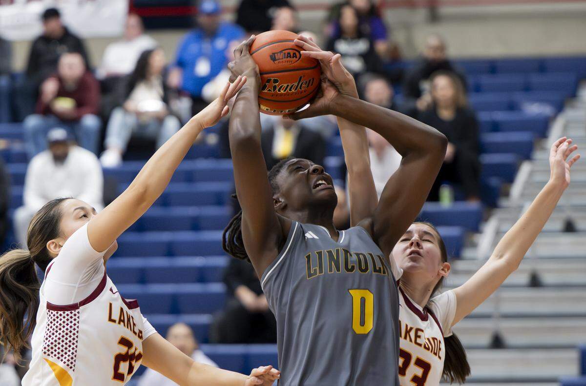 Lincoln forward Oliviyah Edward (0) makes a basket with two Lakeside defenders guarding during the regional round of the 3A state basketball tournament at Bellevue College, on Saturday, Feb. 28, 2026, in Bellevue.