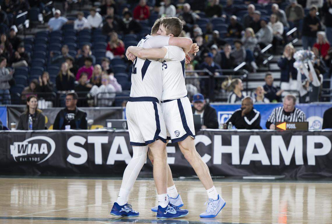 Gonzaga Prep Bullpups forward Dylunn Groves (32) and Gonzaga Prep Bullpups guard Ryan Carney (2) hug after beating Puyallup in double overtime during the quarterfinal round of the 4A State Tournament at the Tacoma Dome, on Thursday, March 5, 2026, in Tacoma, Wash.