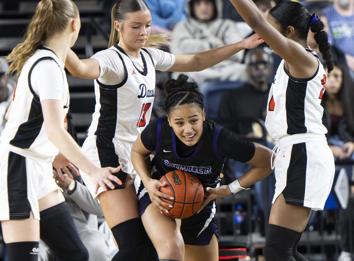 Sumner guard Kawehi Borden (4) is swarmed by Davis defenders during the Girls 4A State Tournament Championship at the Tacoma Dome, on Saturday, March 7, 2026, in Tacoma, Wash.