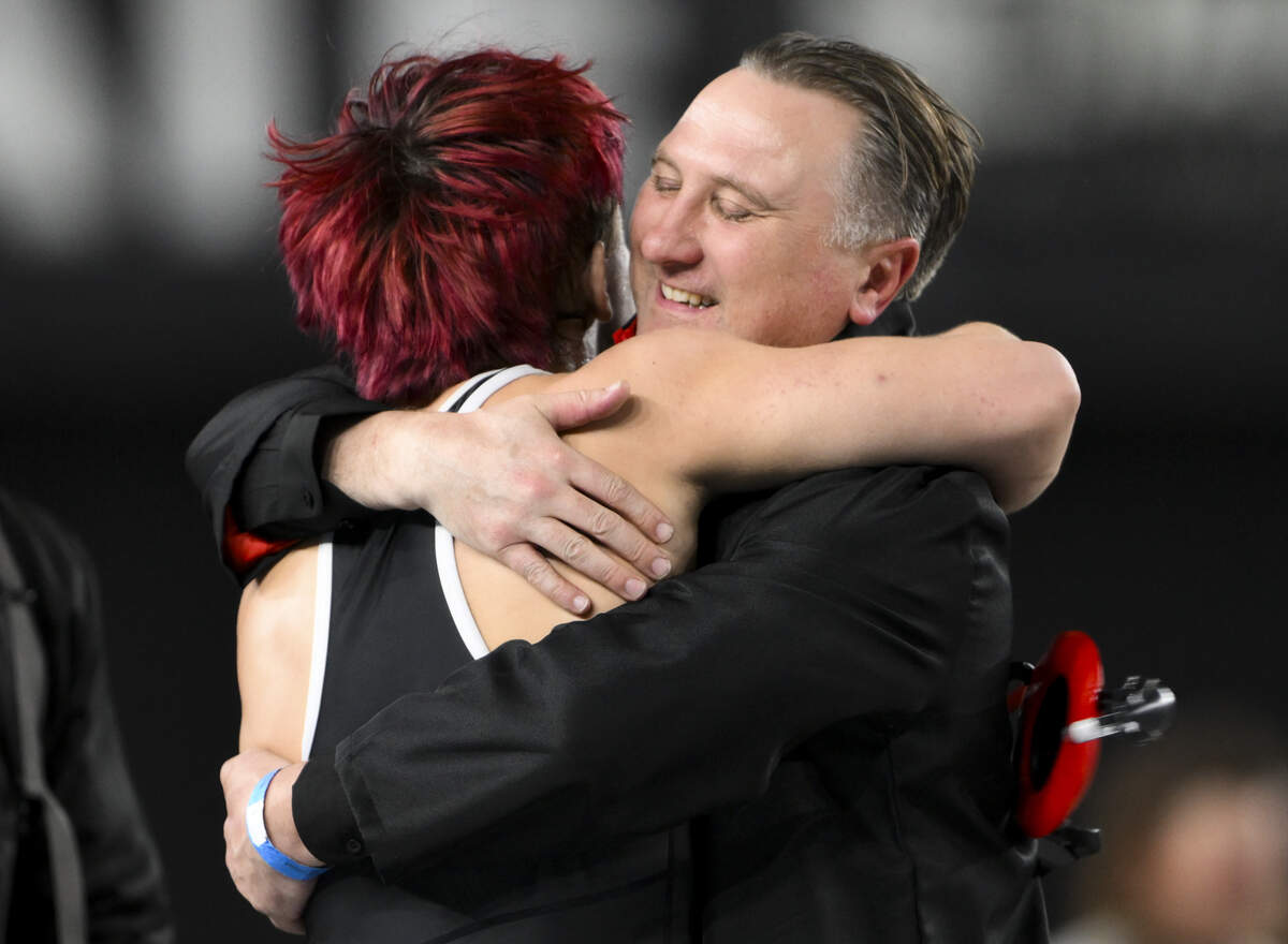 Orting’s Michael Fritz and coach Jody Coleman hug after Fritz’s victory over Deer Park’s Emmitt Priddy in the Boys 2A 165-pound Championship match during the Mat Classic XXXVII at the Tacoma Dome, on Saturday, Feb. 21, 2026, in Tacoma, Wash.